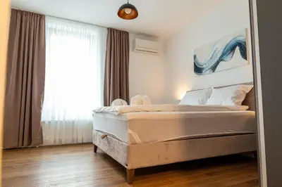 a bedroom with a bed and a large window at Planet Gemini Residence & SPA in Niš