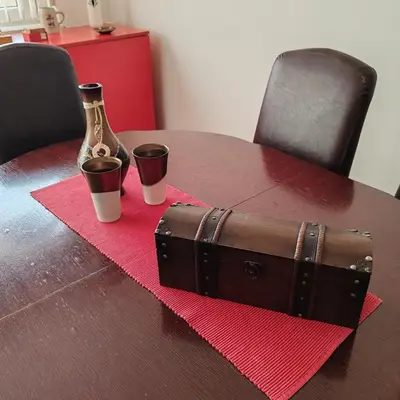 a wooden table with a bottle and two cups on a table at Merak stan na dan in Vranje