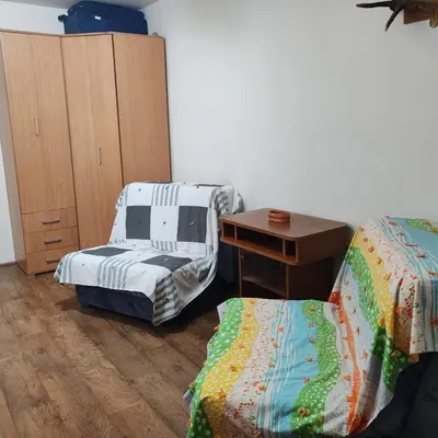 a room with two beds and a desk and a table at Merak stan na dan in Vranje