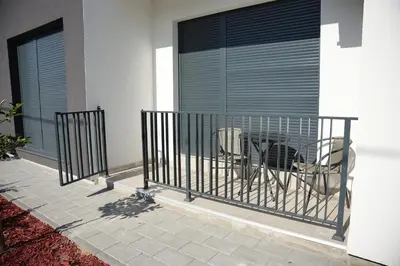 a balcony with a gate with two chairs in it at La Casa in Vrnjačka Banja
