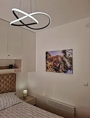 a bedroom with a bed and a chandelier at La Casa in Vrnjačka Banja