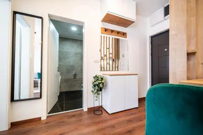a living room with a green couch and a staircase at La Casa in Vrnjačka Banja