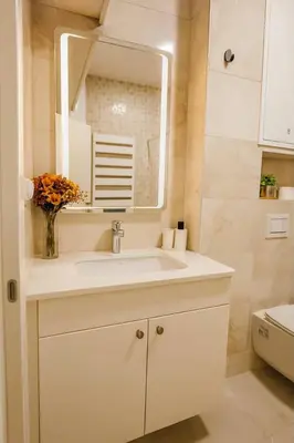 a white bathroom with a sink and a mirror at Luxury Stay in Vrnjačka Banja C1 in Vrnjačka Banja