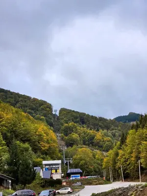 a parking lot with cars parked in front of a mountain at Apartman Mist C113 - Bela Reka in Brzeće