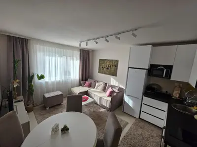 a kitchen and living room with a couch and a table at Apartman Bibi centar in Niš