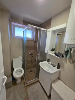 a bathroom with a shower and a toilet and a sink at Apartman Bibi centar in Niš