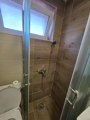 a bathroom with a shower with a toilet and a window at Apartman Bibi centar in Niš