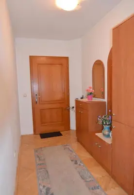 a bathroom with a wooden door and a mirror at Apartman Mandić in Vrnjačka Banja