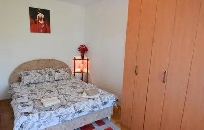 a small bedroom with a bed and a dresser at Apartman Mandić in Vrnjačka Banja