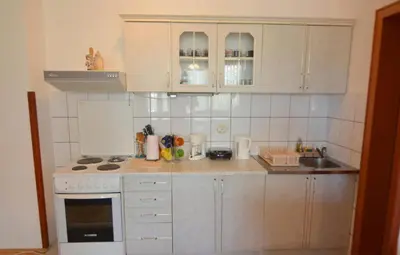 a small kitchen with white cabinets and a sink at Apartman Mandić in Vrnjačka Banja