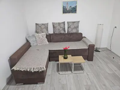 a brown couch in a living room with a table at City Comfort Suite in Paraćin