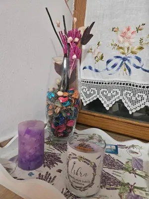 a table with a candle and a vase filled with rocks at Apartman Vila Mir in Vrnjačka Banja