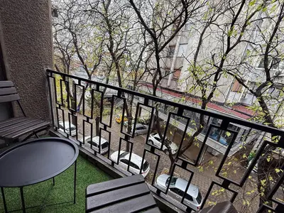 a balcony with a table and chairs and a view of a street at Millenium Apartments City Center in Niš