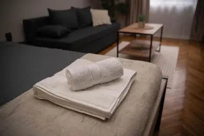 a pile of towels sitting on top of a bed at Millenium Apartments City Center in Niš