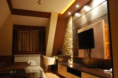 a hotel room with a television and a table and chair at Ski & Relax Apartment in Kopaonik