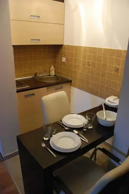 a kitchen with a table with plates and utensils at Ski & Relax Apartment in Kopaonik