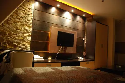 a bedroom with a bed and a tv on a wall at Ski & Relax Apartment in Kopaonik