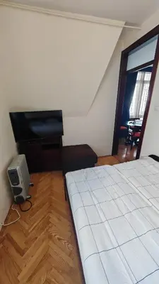 a bedroom with a bed and a flat screen tv at Vila Gorica - Planinska kuca in Kopaonik