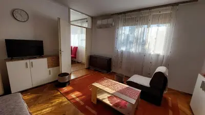 a living room with a couch and a table and a tv at Stan Na Dan Ćuprija in Ćuprija