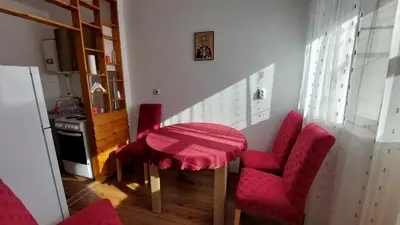 a kitchen with a table and two red chairs at Stan Na Dan Ćuprija in Ćuprija