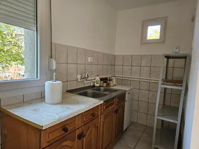 a kitchen with a sink and a ladder next to a window at DiO in Kruševac