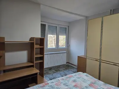 an empty bedroom with a bed and a window at DiO in Kruševac