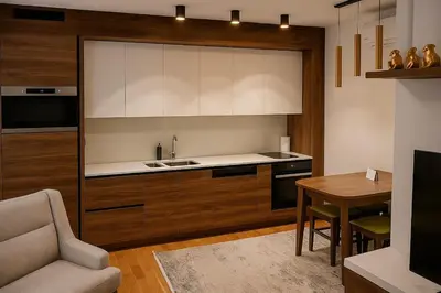a kitchen with wooden cabinets and a table with a chair at Cozy Elegance Apartment D1 in Vrnjačka Banja