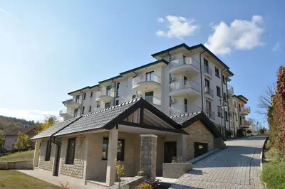 a large white building with a roof at Cozy Elegance Apartment D1 in Vrnjačka Banja