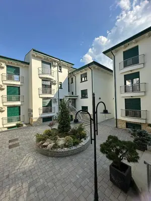 a group of buildings with a courtyard with a tree at Cozy Elegance Apartment D1 in Vrnjačka Banja
