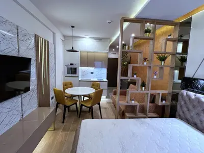 a room with a bed and a table and chairs at Pleasure LUX G999 Kopaonik in Kopaonik