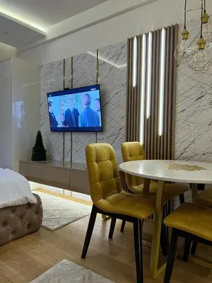 a living room with a table and a tv on a wall at Pleasure LUX G999 Kopaonik in Kopaonik