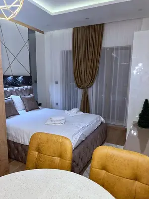 a bedroom with a bed and two yellow chairs at Pleasure LUX G999 Kopaonik in Kopaonik