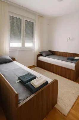 a bedroom with two beds and two windows at Soft Living Family Suite A6 in Vrnjačka Banja