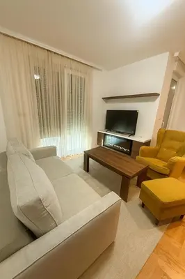 a living room with a couch and a table and a television at Soft Living Family Suite A6 in Vrnjačka Banja
