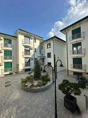 a group of buildings with a courtyard with a tree at Soft Living Family Suite A6 in Vrnjačka Banja