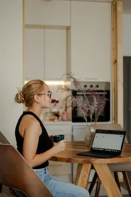 a woman sitting at a table with a laptop computer at LALA & DAUGHTERS Apartment in Vrnjačka Banja