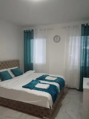 a bedroom with two beds and a clock on the wall at Green place in Jagodina