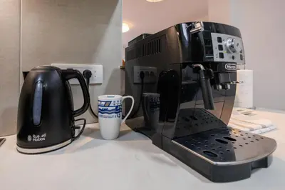 a coffee maker sitting on a counter next to a cup at Pirot LUX 1 in Pirot