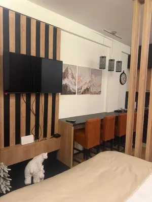 a living room with a table and a tv at N-LUX 66 MILMARI kopaonik in Kopaonik