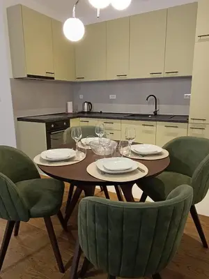 a kitchen with a table and chairs with wine glasses at Planet Green Residence in Niš