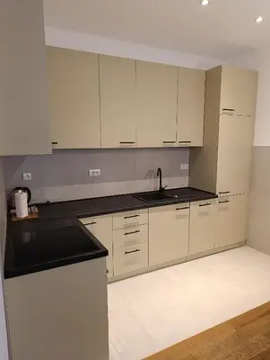 an empty kitchen with white cabinets and a sink at Planet Green Residence in Niš