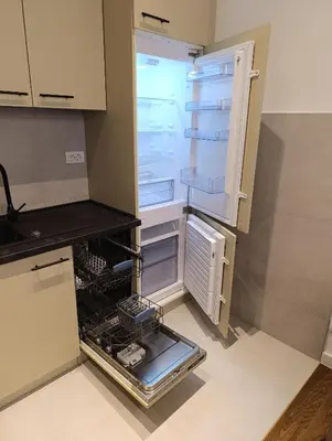an empty refrigerator with its door open in a kitchen at Planet Green Residence in Niš