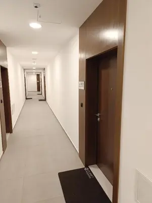 an empty hallway with a door and a carpet at Planet Green Residence in Niš