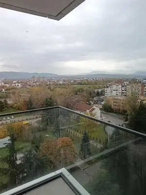 a view of a city from a glass balcony at Planet Green Residence in Niš