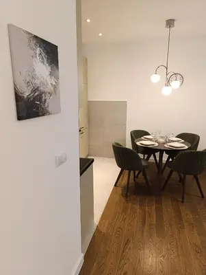 a dining room with a table and chairs at Planet Green Residence in Niš