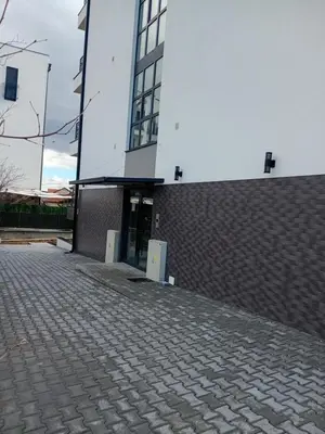 a large white building with a brick driveway at Apartman Rajska Vila in Vrnjačka Banja