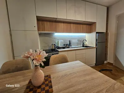 a kitchen with a table and a vase with flowers on it at Blue Wave Vrnjacka banja in Vrnjačka Banja