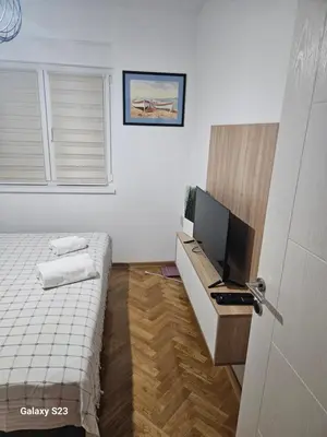 a small bedroom with a bed and a television at Blue Wave Vrnjacka banja in Vrnjačka Banja