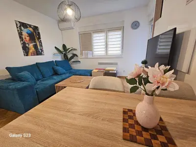 a living room with a blue couch and a table at Blue Wave Vrnjacka banja in Vrnjačka Banja