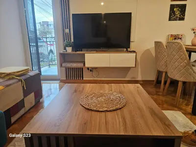 a living room with a tv and a coffee table at Blue Wave Vrnjacka banja in Vrnjačka Banja